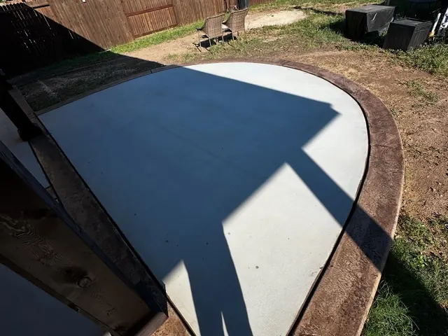 Curved stained concrete patio with a dark finish