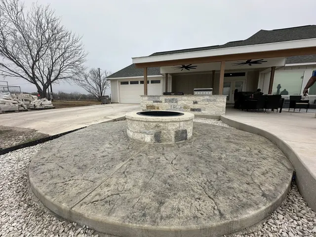Round stamped concrete patio with a built-in fire pit