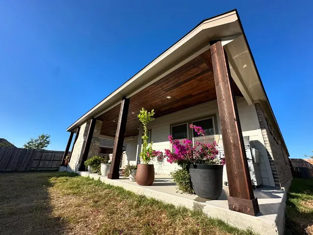 Attached patio cover with cedar posts and planted beds
