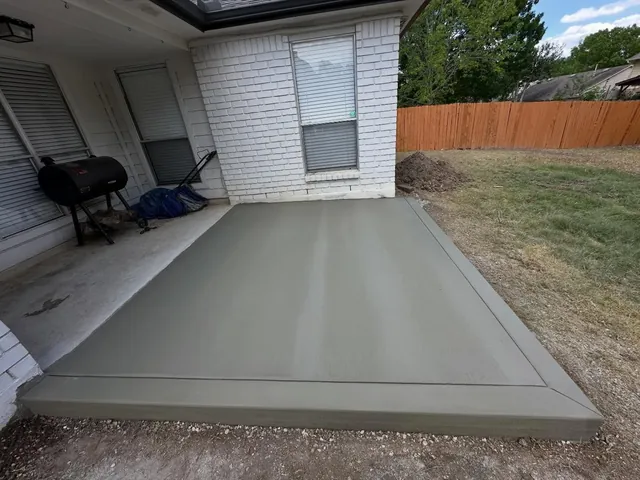 Broom-finish concrete patio extension with a smooth border